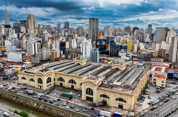 Mercado municipal de São Paulo com estrutura arquitetônica característica e movimento de compradores