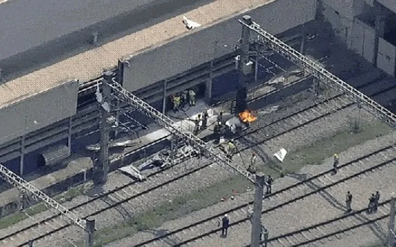Avião monomotor destruído após queda nos trilhos do metrô de Belo Horizonte com fumaça e chamas visíveis