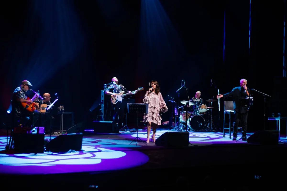 Apresentação musical ao vivo com violão e vocalistas em palco de festival
