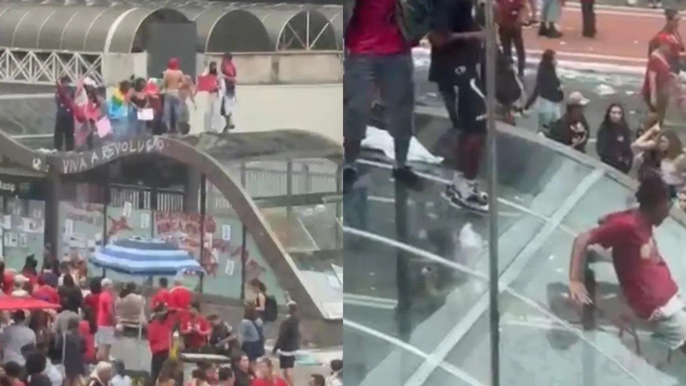 Multidão de pessoas, muitas vestindo vermelho, em manifestação na Avenida Paulista. À esquerda, manifestantes sobre uma estrutura de concreto com a frase VIVA