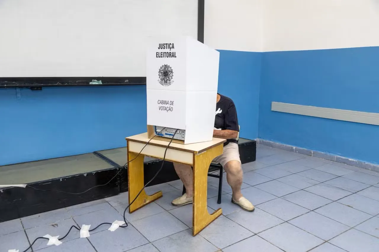 Cédula de votação e urna eletrônica durante o processo de eleição no Brasil
